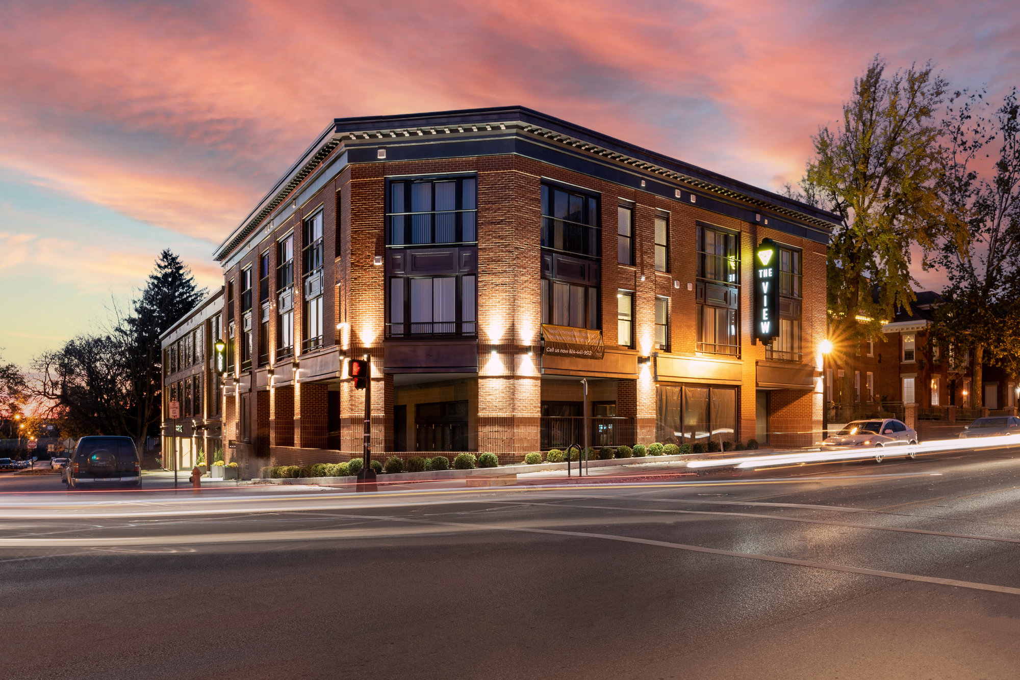 Brick commercial building on a street corner at dusk