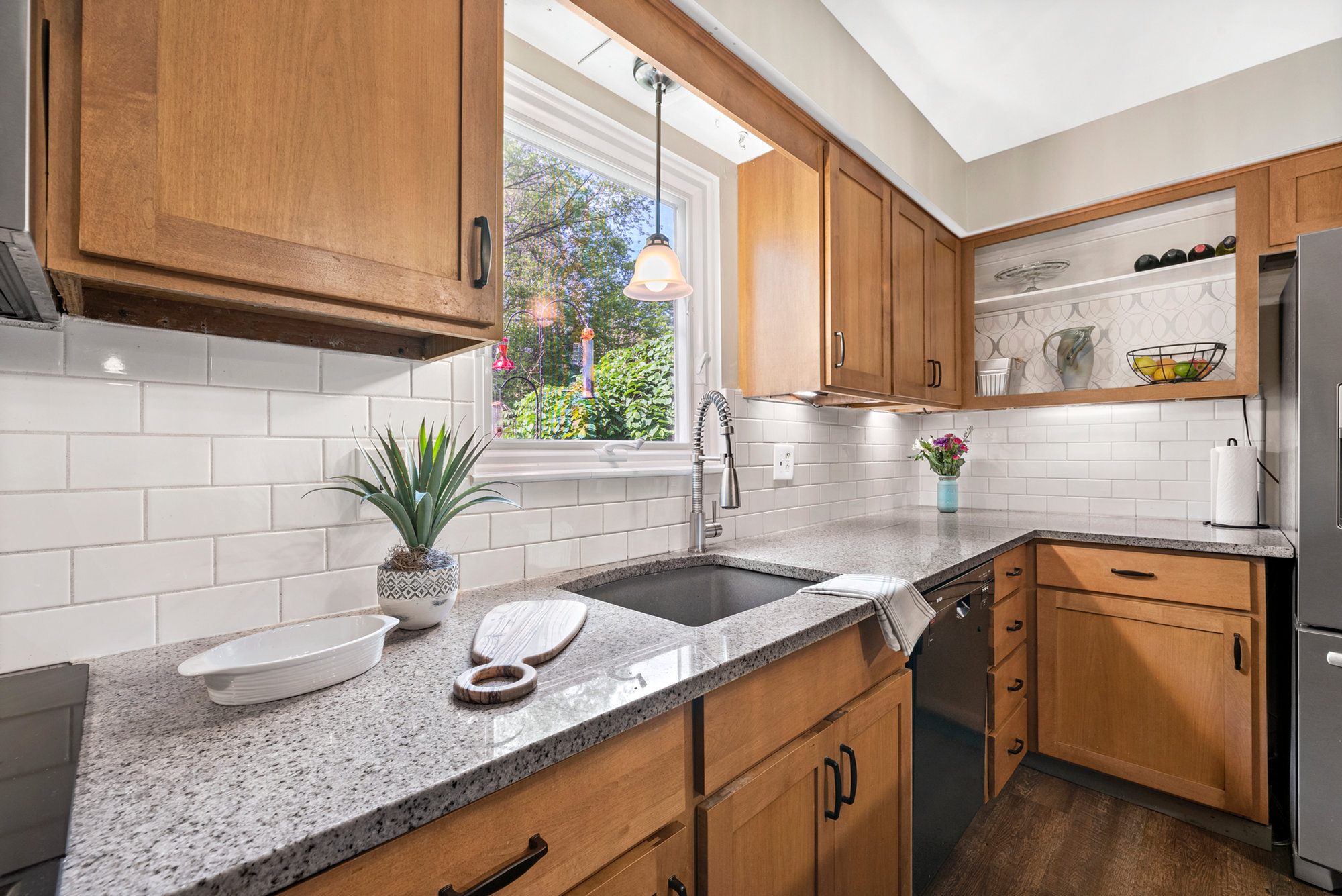 Kitchen with wood cabinetry, stone countertops and a farmhouse sink