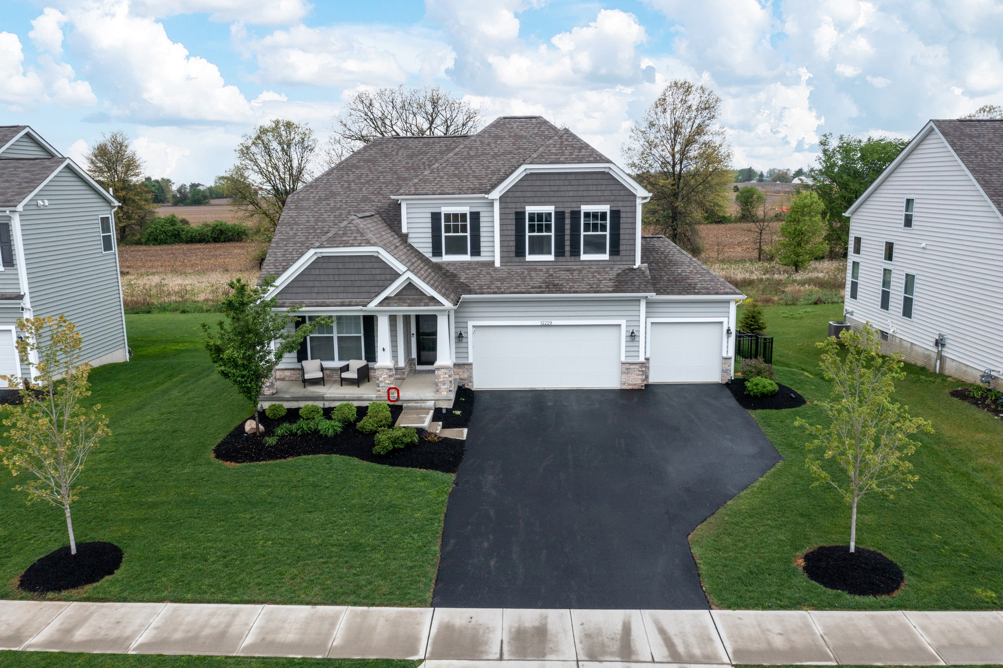 Elevated view of a two-story home with attached garage and front lawn