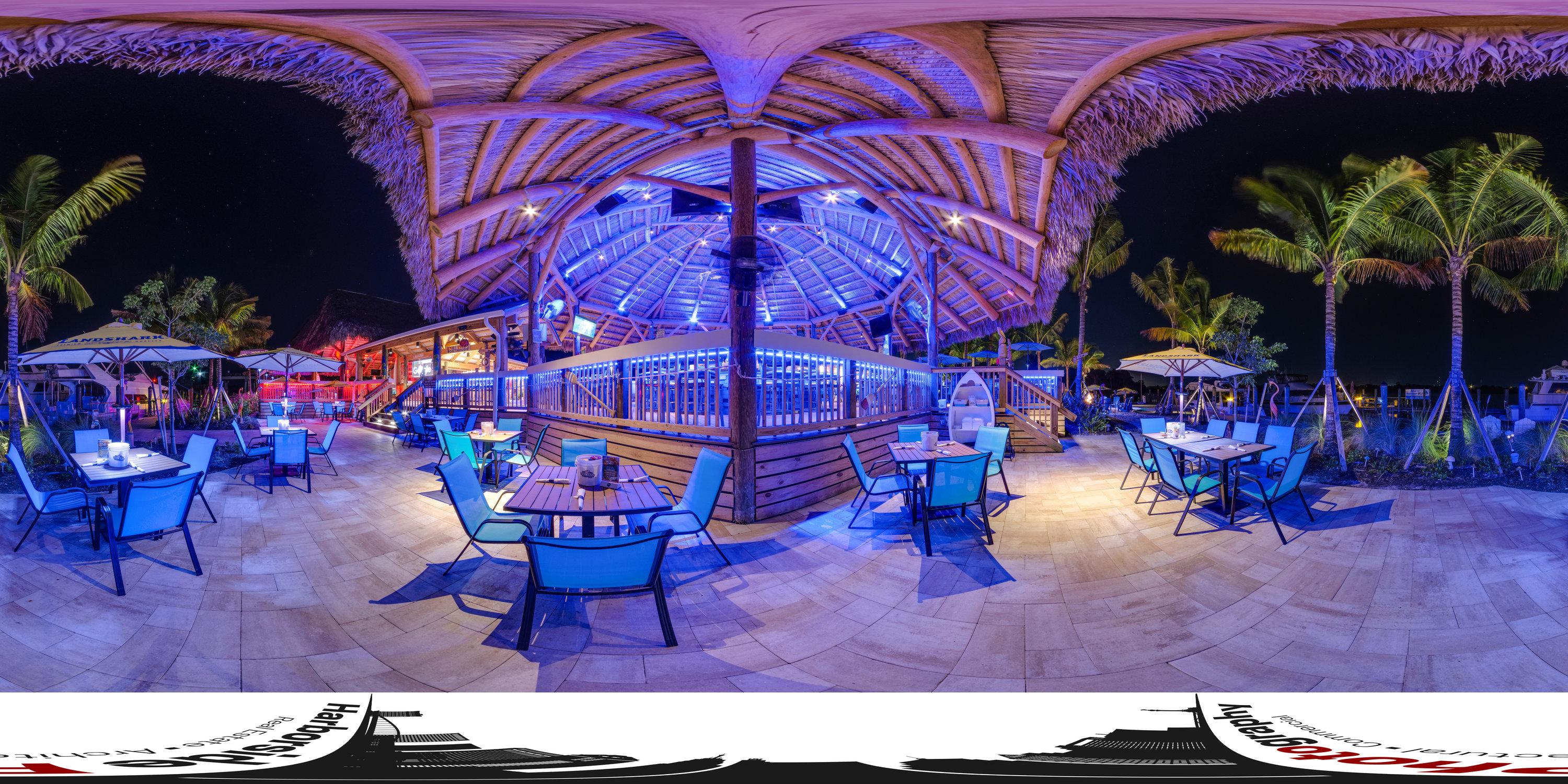 360-degree panorama of a resort pavilion and pool area illuminated at night