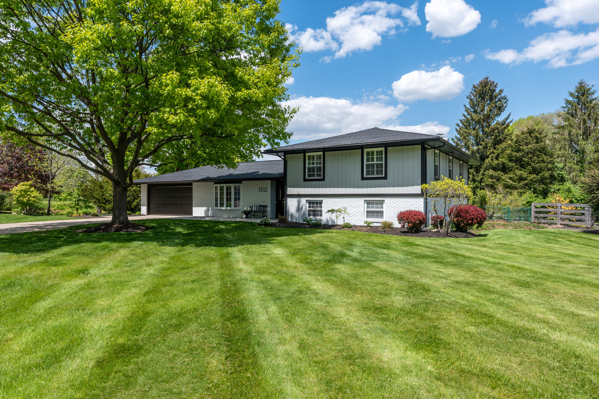Home exterior surrounded by green lawn and trees