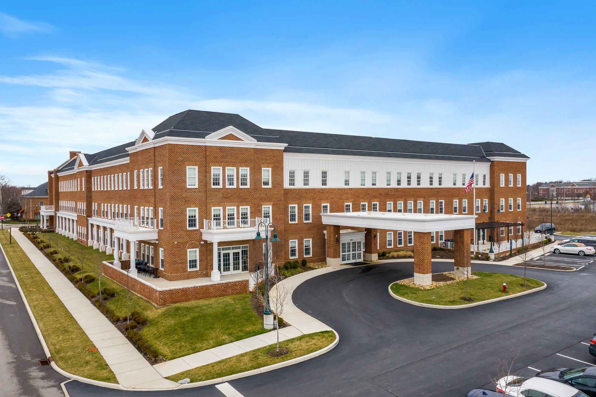 Aerial view of a brick commercial development with parking and a curved entrance