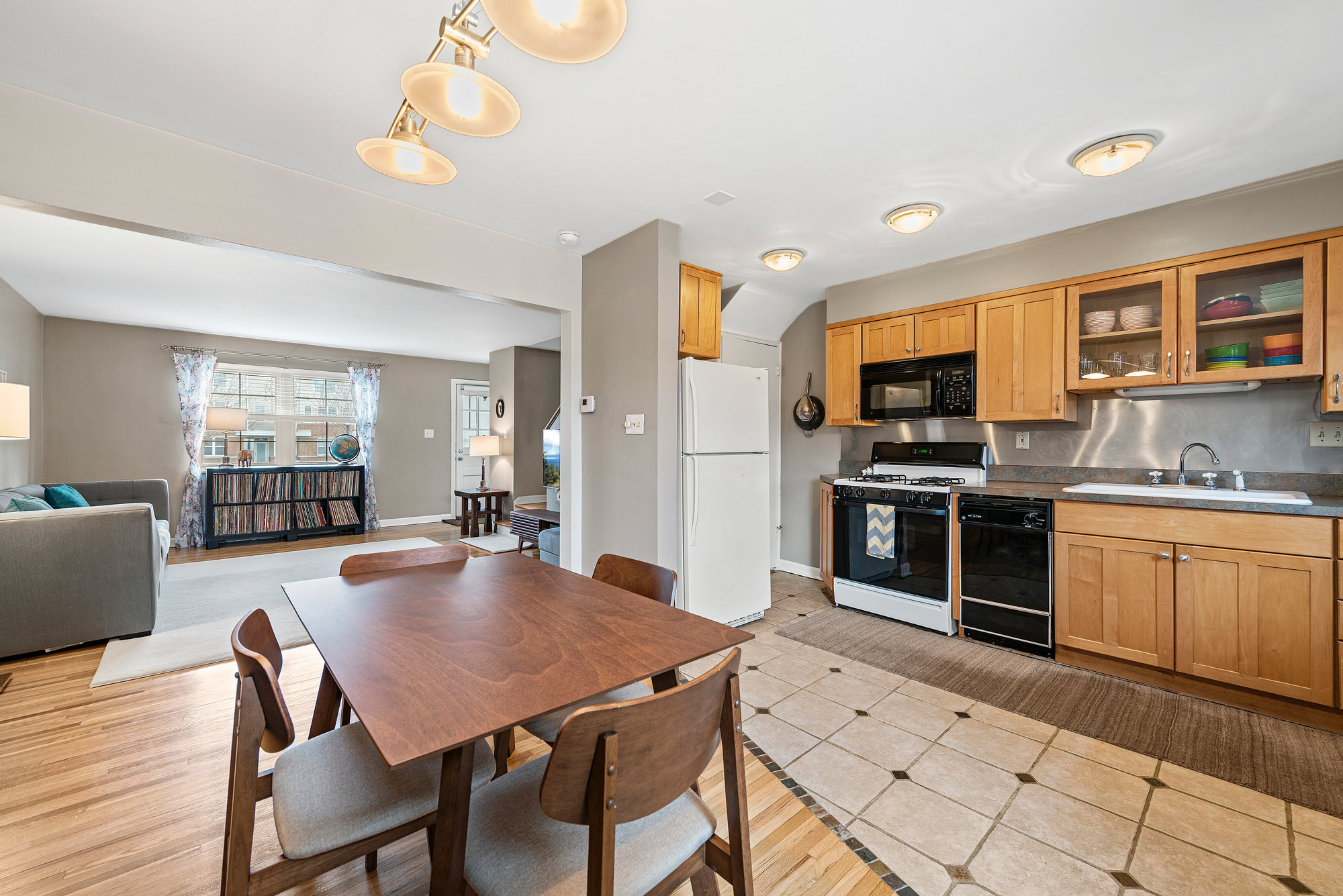 Open kitchen and dining area with wood cabinetry and wood floors