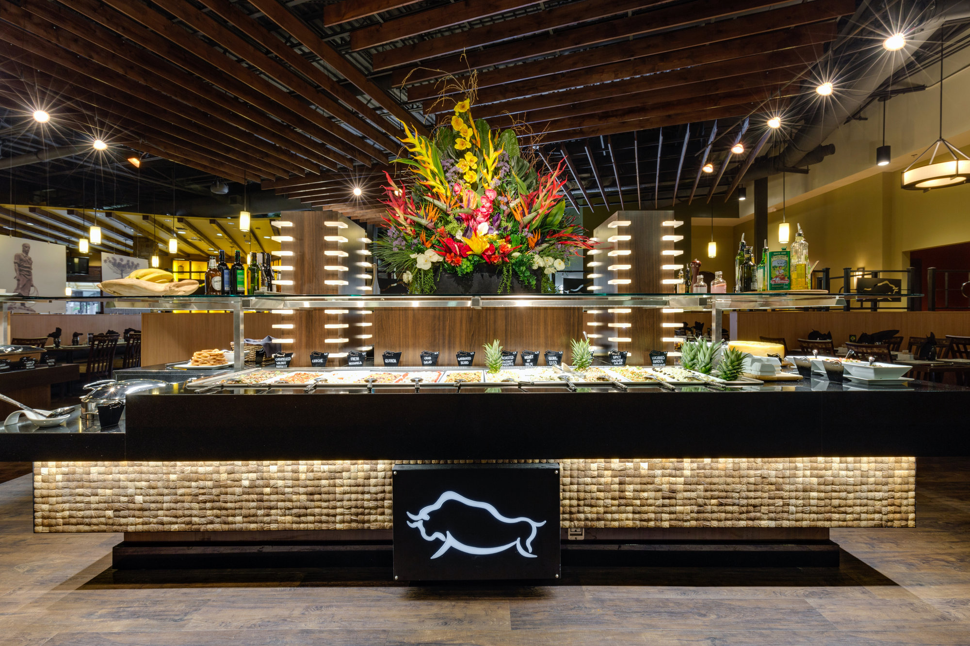 Restaurant buffet counter with floral display and dramatic lighting