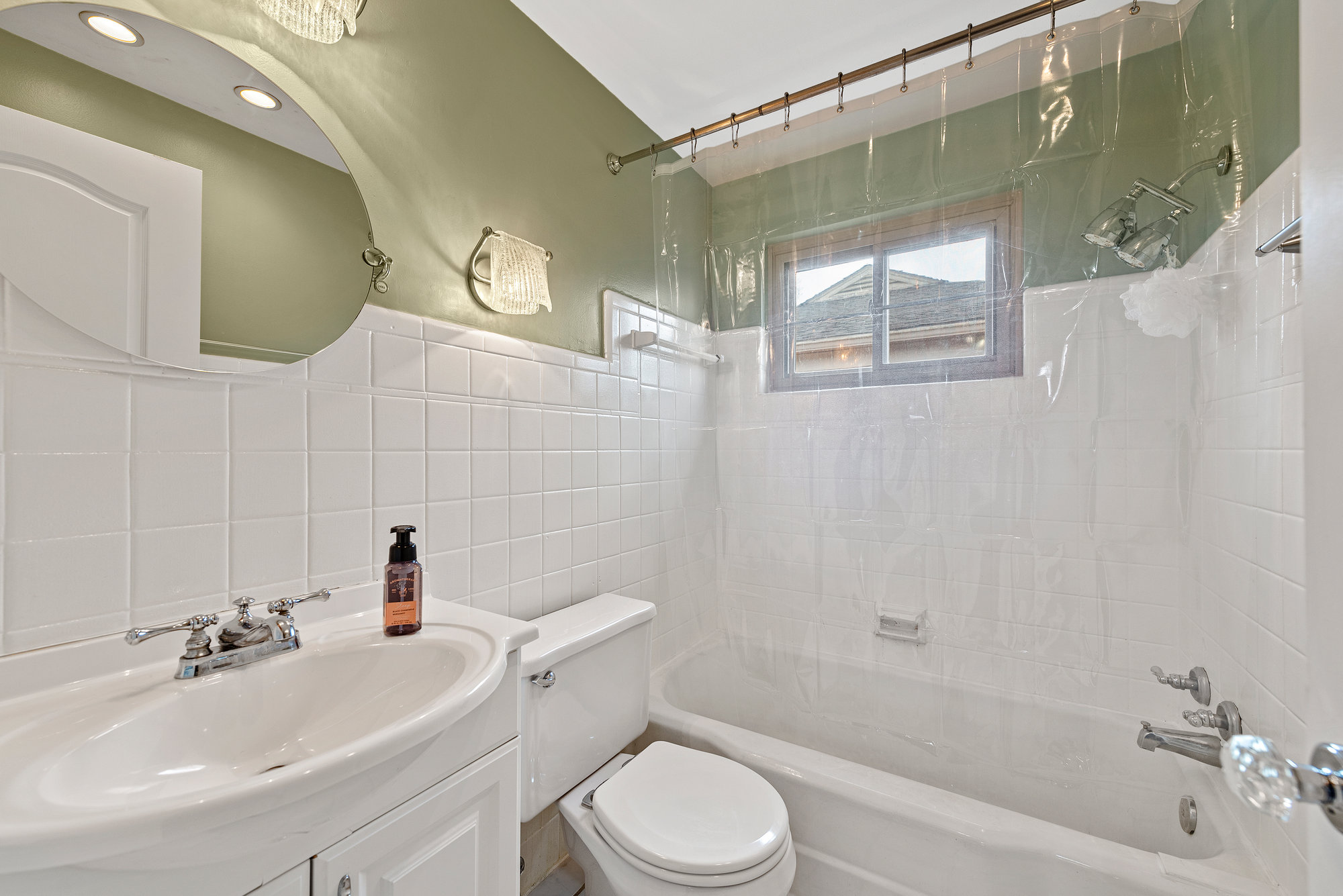 Bathroom with a bathtub, tiled shower surround and pedestal sink