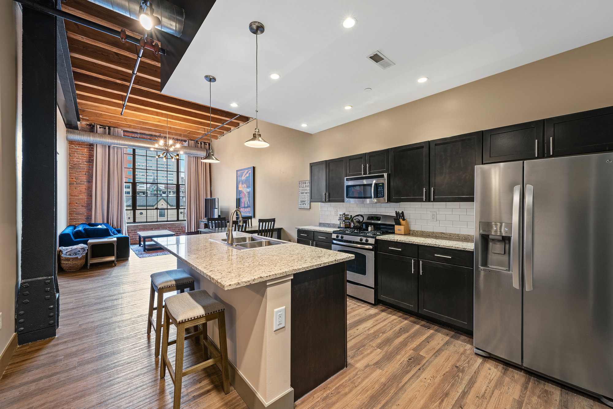 Kitchen with dark cabinetry and stone countertops