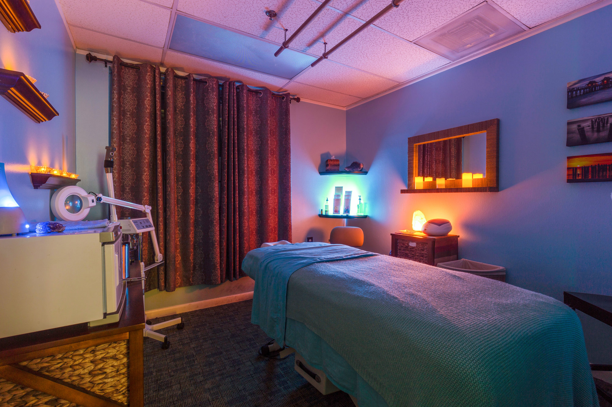 Spa treatment room with massage table and colorful lighting