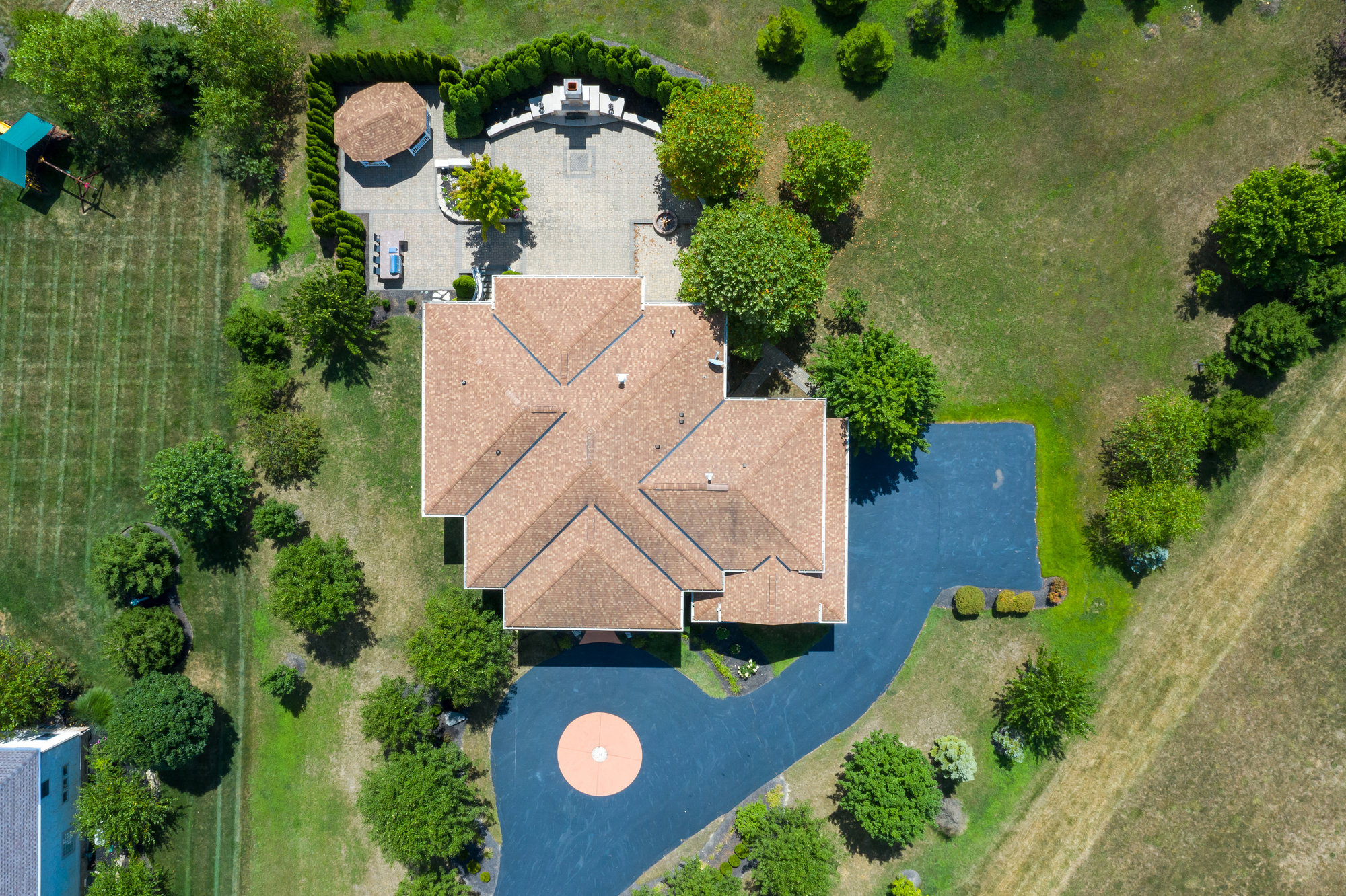 Overhead aerial view of a home, driveway and surrounding lawn