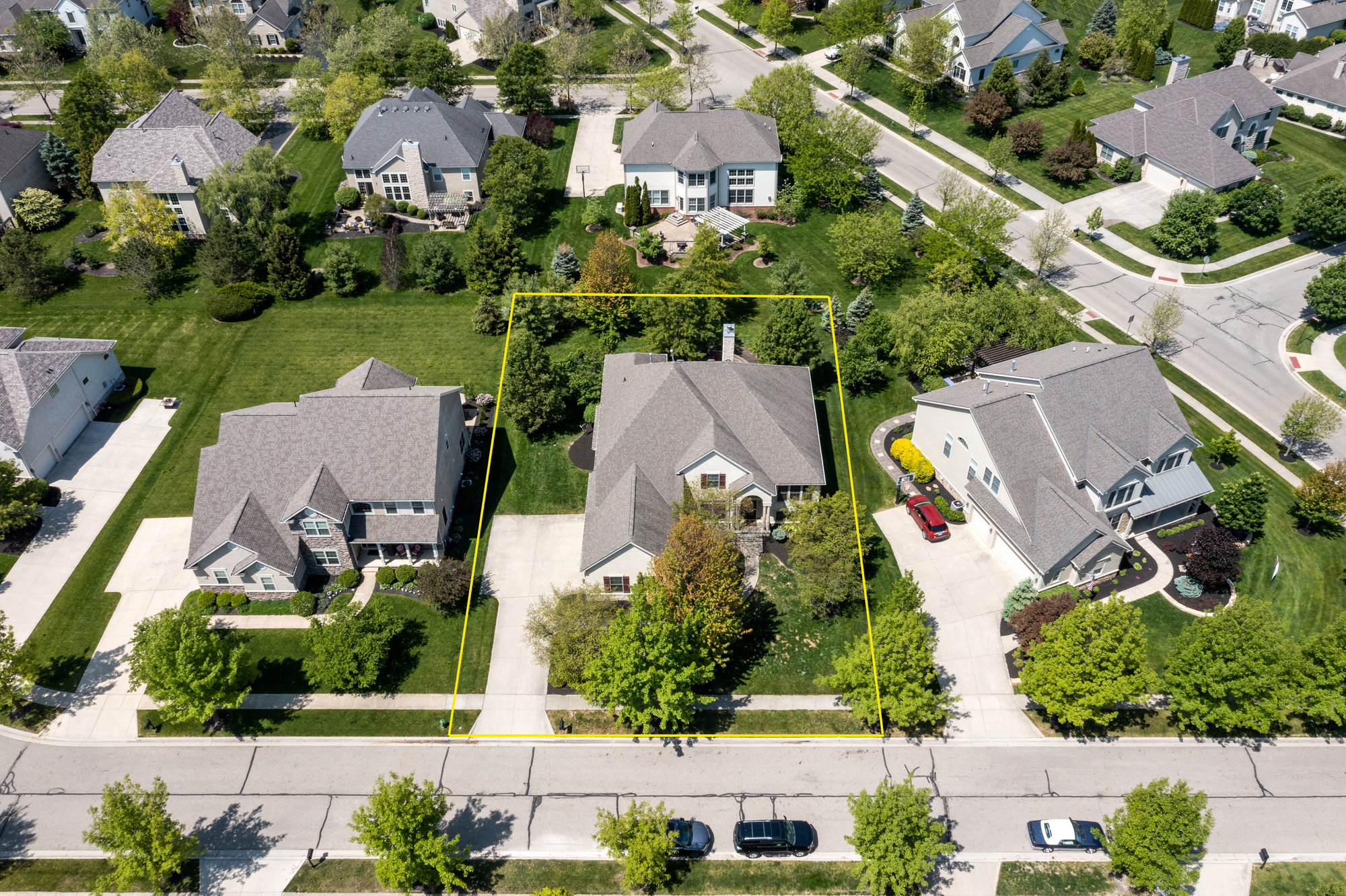 Aerial view of a residential neighborhood with homes, lawns and driveways