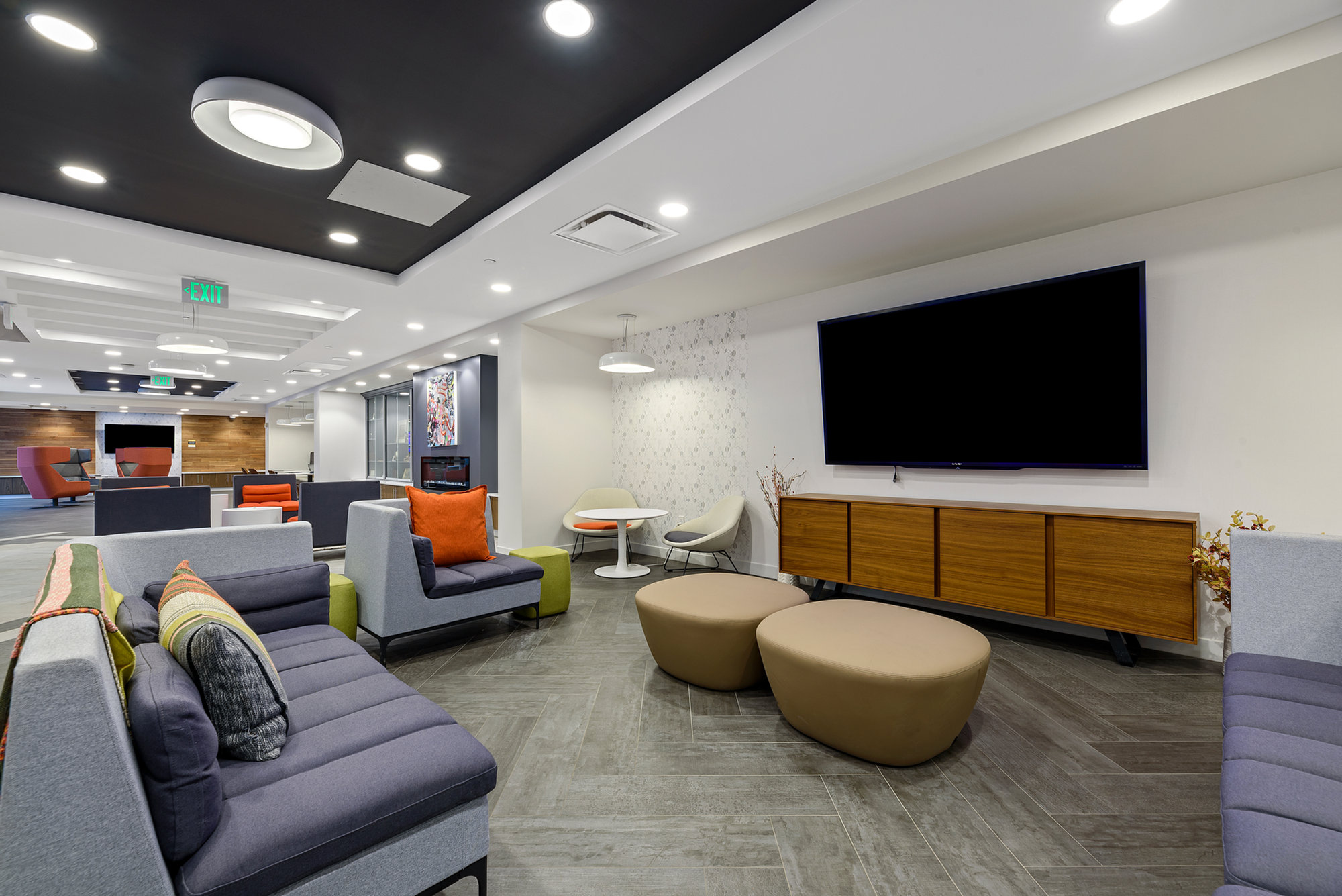 Living room with sectional sofa, wall-mounted television and recessed lighting