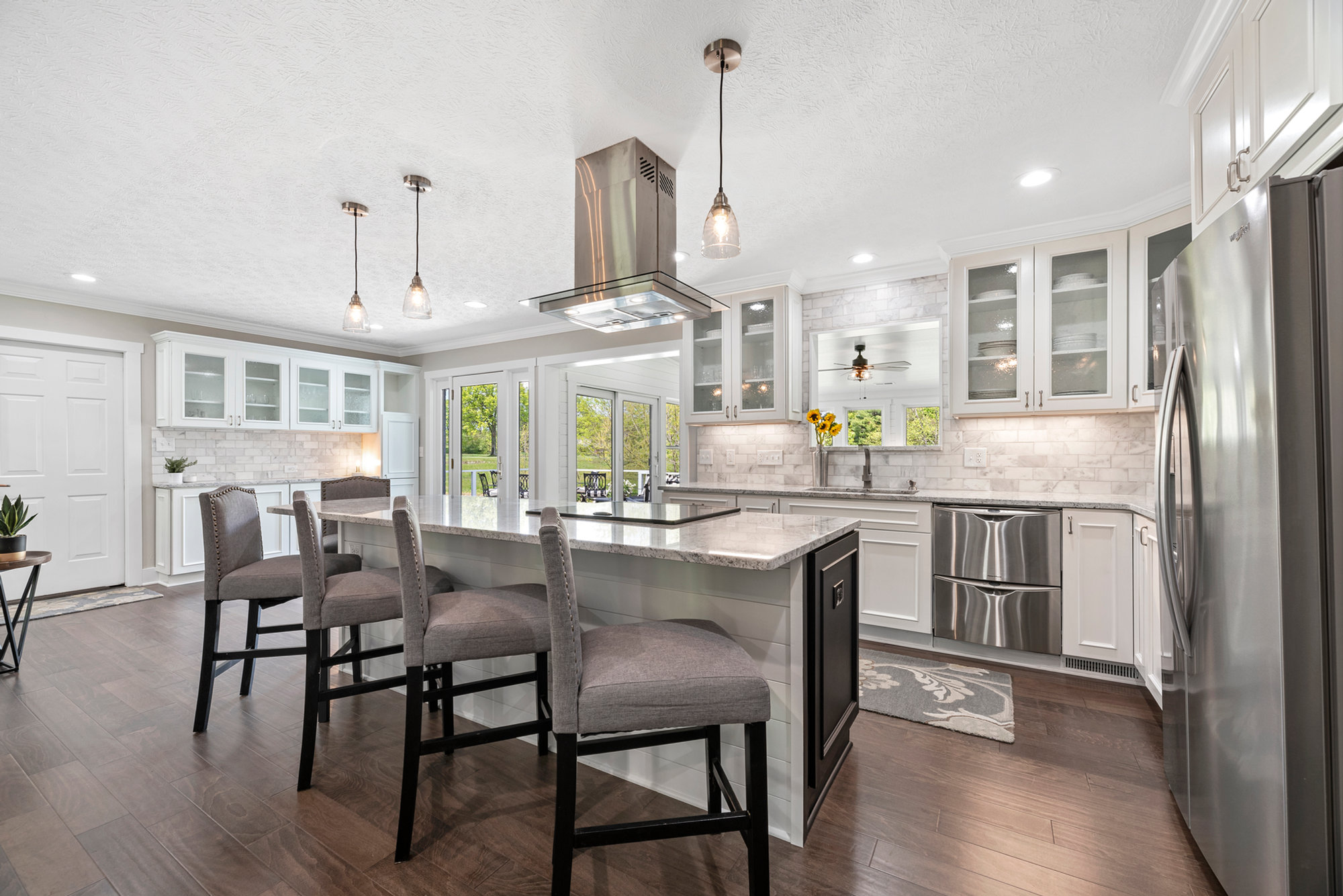 Open kitchen and dining area with white cabinetry and large windows